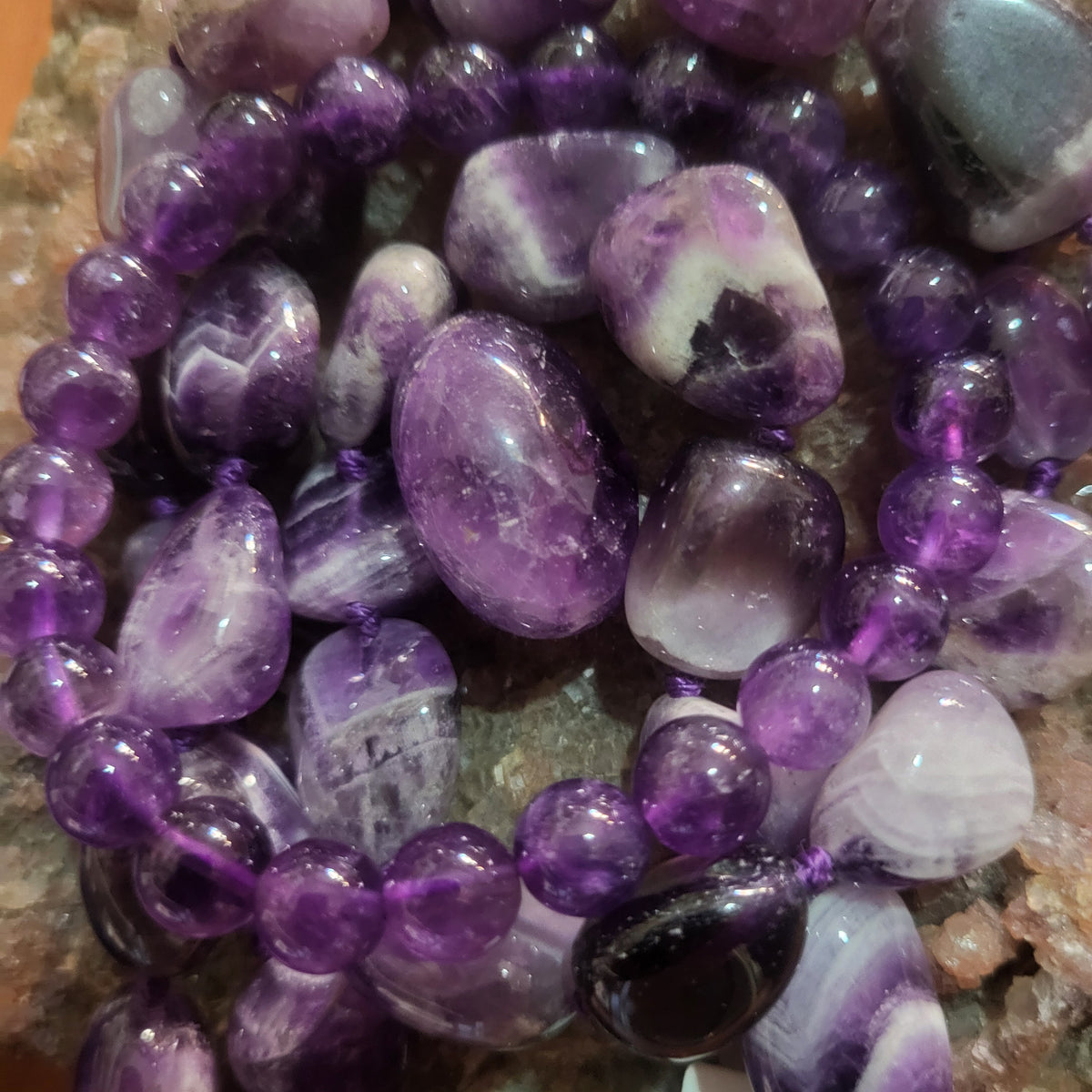 Dettaglio delle perline viola e bianche della collana