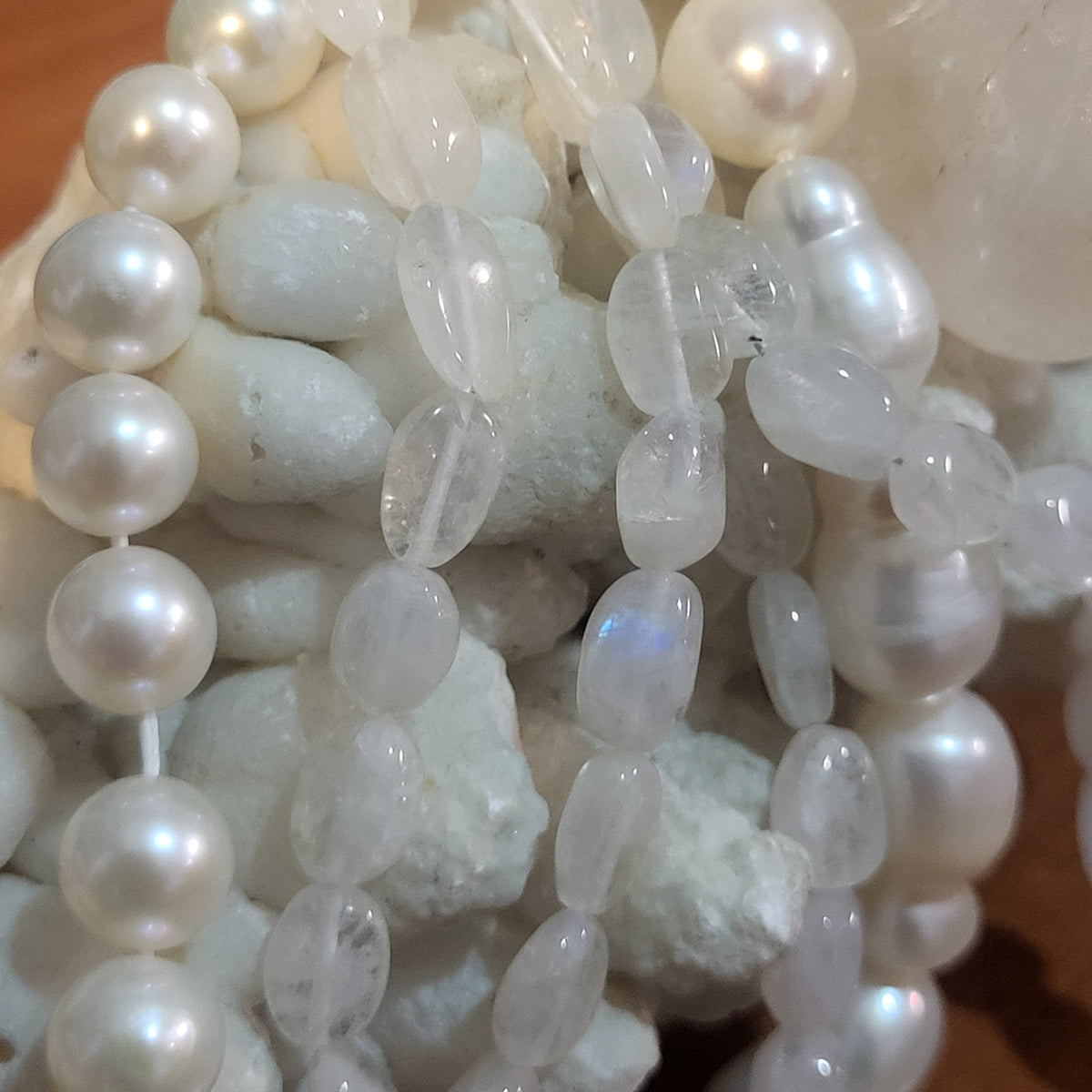 Dettaglio di collana con perline bianche lucide ed elementi traslucidi